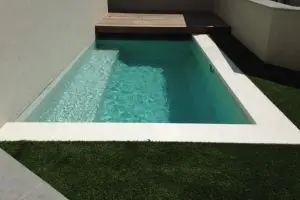 Automatic pool cover retracted to reveal swimming pool